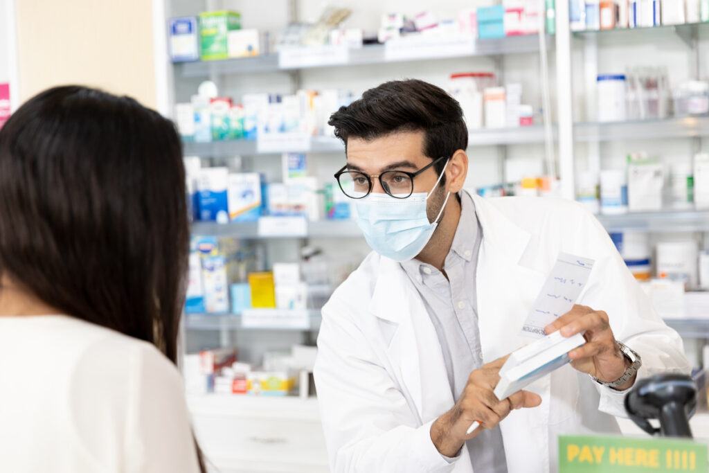middle eastern male pharmacist wearing protective hygienic mask